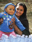femme tenant son bébé dans les bras, tous deux portent du maquillage traditionel
